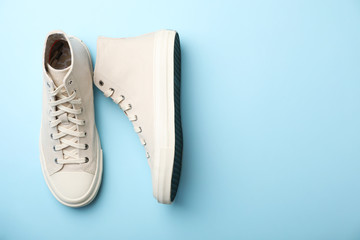 Pair of stylish sneakers on color background, top view