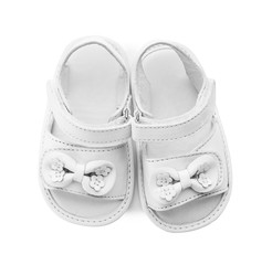 Pair of cute baby sandals decorated with bows on white background, top view