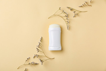 Fototapeta na wymiar White deodorant and herbs on color background