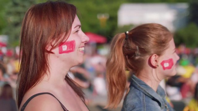 Side view of two football female fans in fan zone