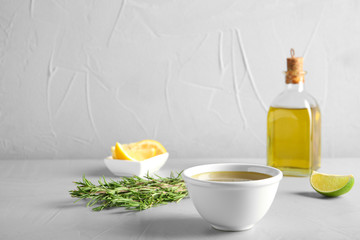 Bowl with fresh rosemary oil on table