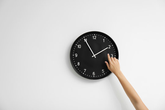 Woman pointing on clock against white background. Time concept