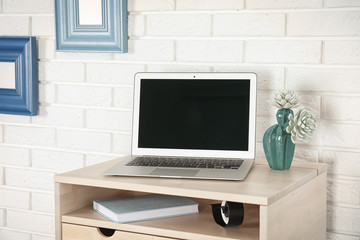 High wooden table with laptop as stand up workplace in modern interior