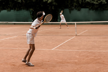 retro styled tennis players playing at tennis court