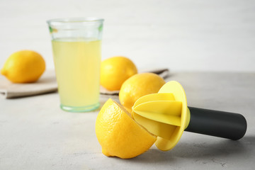 Fresh ripe lemon and reamer on table