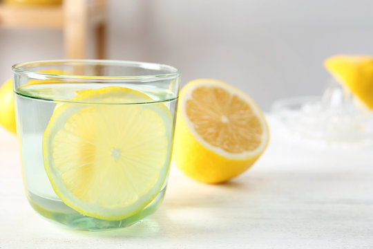 Glass of water with lemon slice on table