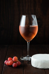 Still life with pink wine, brie cheese and grapes