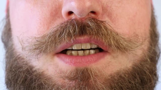 uomo con la barba folta che parla veloce