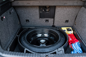 Spare tyre, first aid kit and tow rope in back of car / car boot