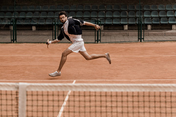 Obraz premium retro styled handsome man playing tennis at tennis court