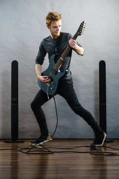 Young man playing electric guitar