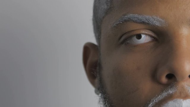 Half face portrait of demonic Afro-American Man with white eyes and lips