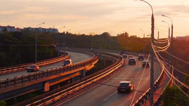 City traffic on asphalt road or highway route at sunset time, lot of cars drive with fast speed, urban transportation cityscape scene