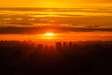 Obraz premium City during warm sunset. Cityscape panorama at summer sunset. Orange sky on sunset in big city. Saint-Petersburg skyline in sunset, Russia.