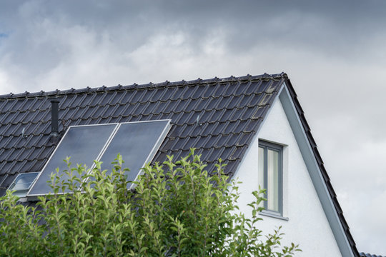 roof with solar panels against dark clouds