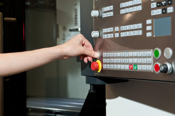 Female hand presses buttons on the machine control panel