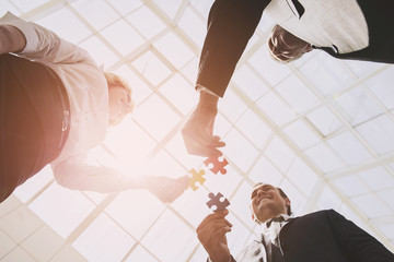 Three Smart Business Partners with Jigsaw Puzzles.