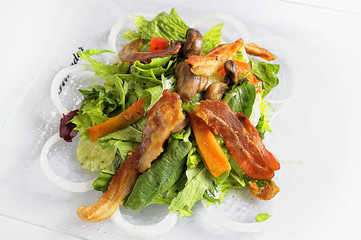 Green salad in a bowl, with spinach and bacon.