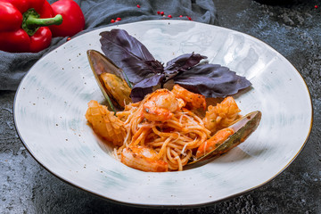 Pasta with seafood on black concrete