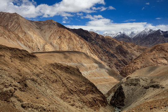 ChangLa Pass, Ladakh India. High Altitude mountain pass, snow mountains in the background with a canyon/valley in the foreground. Road between Zingral and Durbuk. Grand landscape with huge mountains.