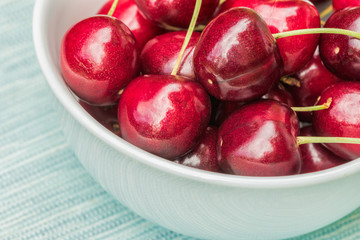 Bright red cherries in a white ceramic bowl