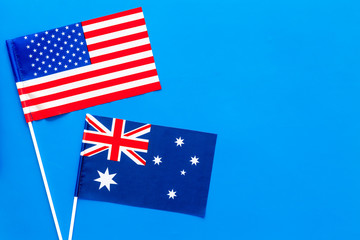 USA-Australia relations. Country cooperation. American and Australian flags on blue background top view copy space