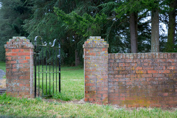 A brick fence with an iron gate