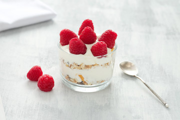 Breakfast with yogurt, raspberries and floaks.