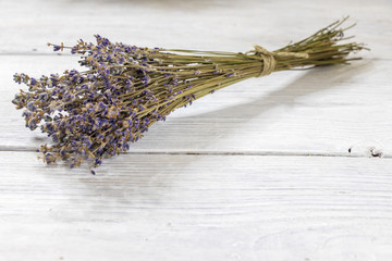 background. bouquet of dry twigs of lavender lies on a white wooden table