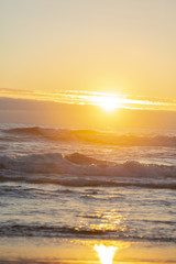 Ocean sunset. Sun reflecting from ocean waves. Lens flares from sun.