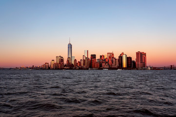 New York city skyline sunset view from the boat to Ellis Island - obrazy, fototapety, plakaty