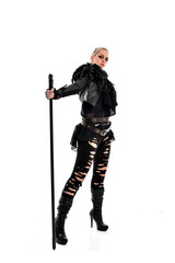 full length portrait of blonde girl wearing black gothic outfit, holding a staff. standing pose, isolated on white studio background.