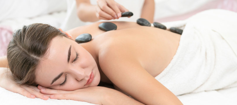 Hot Stone Massage Treatment By Therapist In Spa.