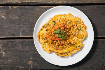 Omelet (Omelette, Scrambled) with instant noodle on top on old wood table