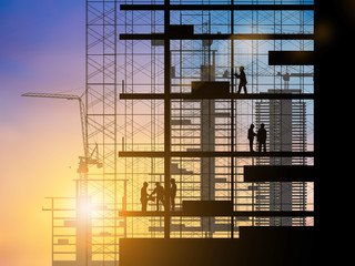 Silhouette of engineer and construction team working at site over blurred background sunset pastel for industry background with Light fair.Create from multiple reference images together.