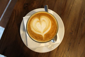 A cup of hot cafe latte (plus its latte art)