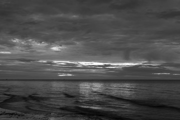  The sun began to rise from the sea in the morning backdrop black and white style.
