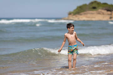 Young boy playing in the Ionian sea, Chalikounas beach, Corfu island, Greece