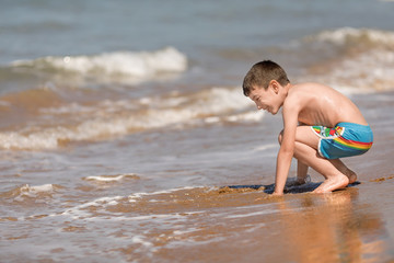 Young boy playing in the Ionian sea, Chalikounas beach, Corfu island, Greece