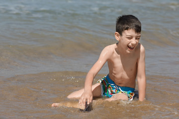 Young boy playing in the Ionian sea, Chalikounas beach, Corfu island, Greece