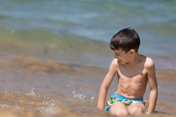 Young boy playing in the Ionian sea, Chalikounas beach, Corfu island, Greece