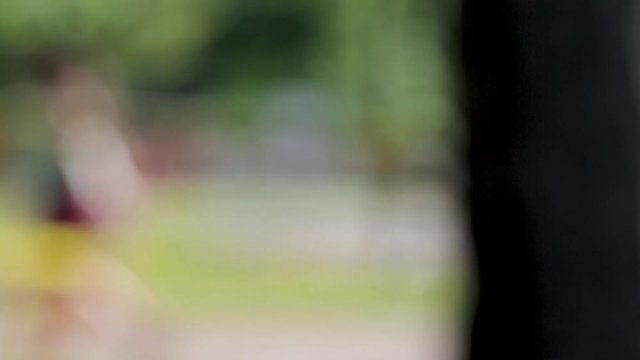Blurred People walking in the park panoramic view finishing on a cicada shell hanging from a tree trunk.  Human and insect relationship. Summer time in a park. 