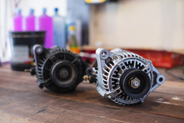New and old automotive power generator alternator for car on wooden table background.
