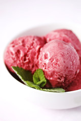 Raspberry ice cream in white bowl