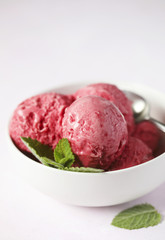 Raspberry ice cream in white bowl