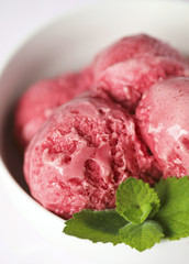 Raspberry ice cream in white bowl
