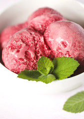 Raspberry ice cream in white bowl