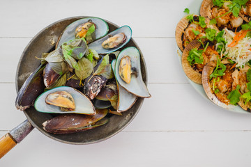 special Thai seafood Herb Roasted Mussels and Scallops Butter on white table background. party concept.