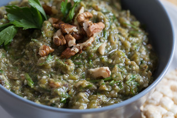 Close-up of Kiopooolu, a side dish prepared from grounded roasted eggplant and peppers, decorated with parsley and walnuts