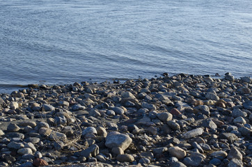 The small rock shoreline of the dry and dead great salt lake in the summer sun. 